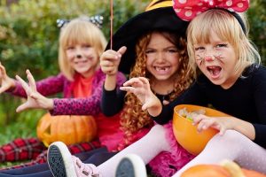 Young girls with Halloween treats in plastic pumpkins